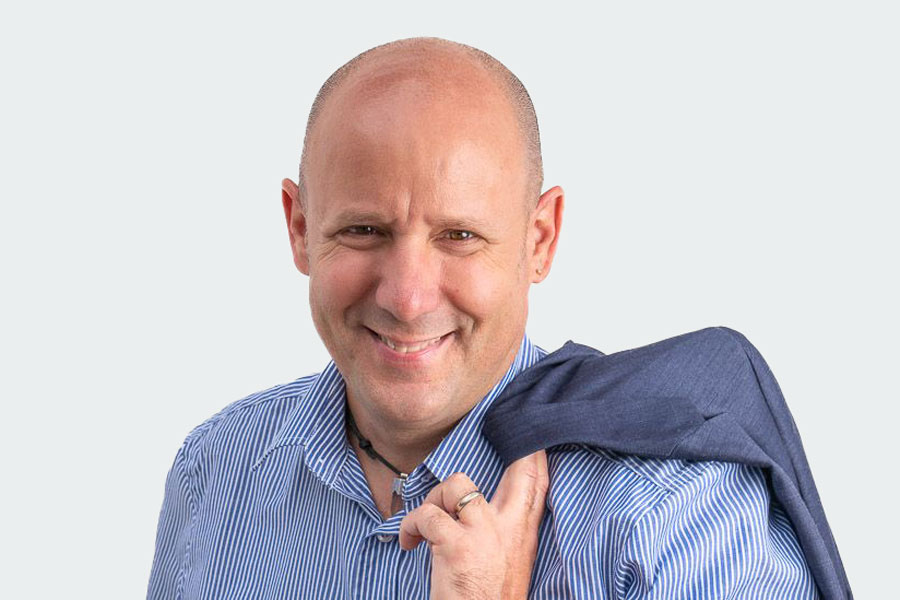 Marc Schärer, Head of the Industry department. He is wearing a blue and white striped shirt and a blue vest over his shoulder.