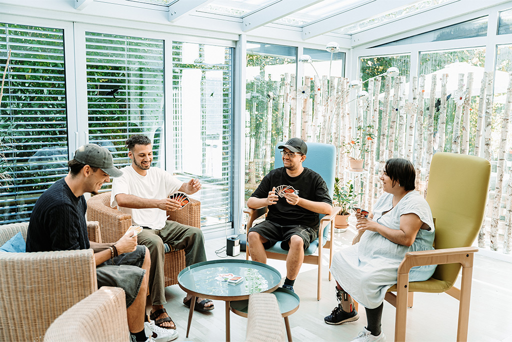 4 Personen spielen ein Kartenspiel