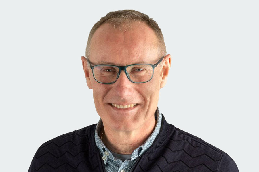 Hugo Spengler, member of the Board of Trustees, representative of the insieme parents' association. He wears glasses, a patterned shirt and a blue sweater.