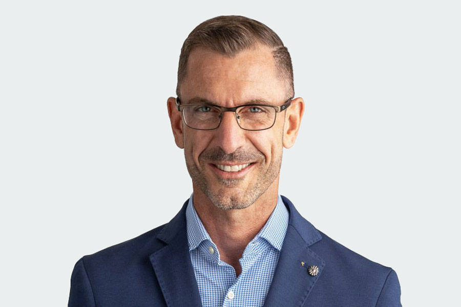 Mann mit blau-weiss kariertem Hemd, Brille und dunkelblauem Veston. Sein Name ist Alain Thomann. Er ist Geschäftsführer der Altra.