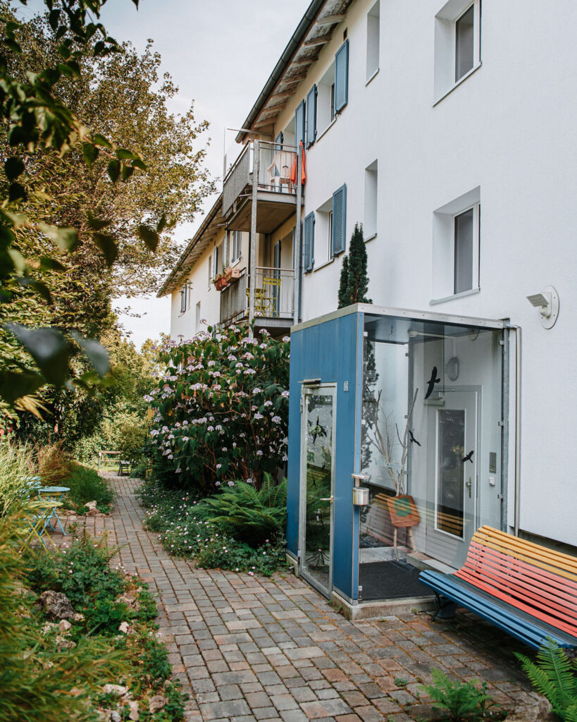 Entrance to a house. The house is white, the entrance to the property is blue and covered.