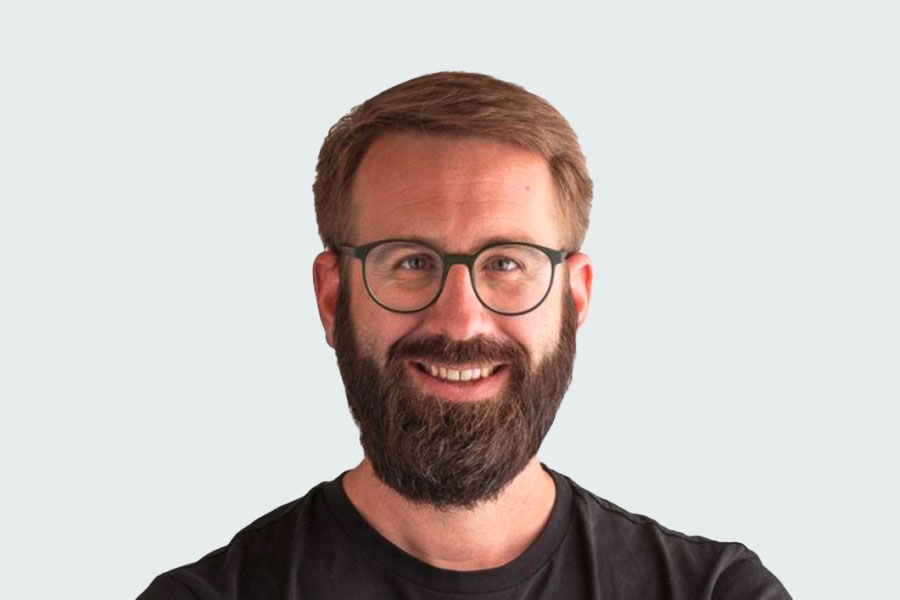Ralf Stoll, Gruppenleiter Schreinerei. Er trägt Brille einen Vollbart und ein braunes T-Shirt.