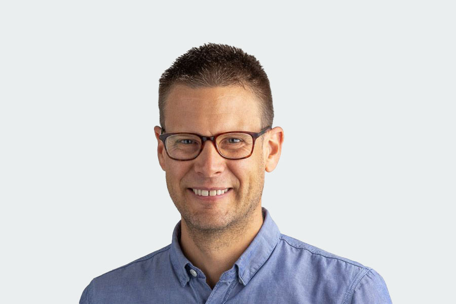 Man with blue shirt, short hair and glasses smiles at the camera. His name is Simon Bühler. He is the head of the Employee Department and the contact person when it comes to sheltered workplaces.