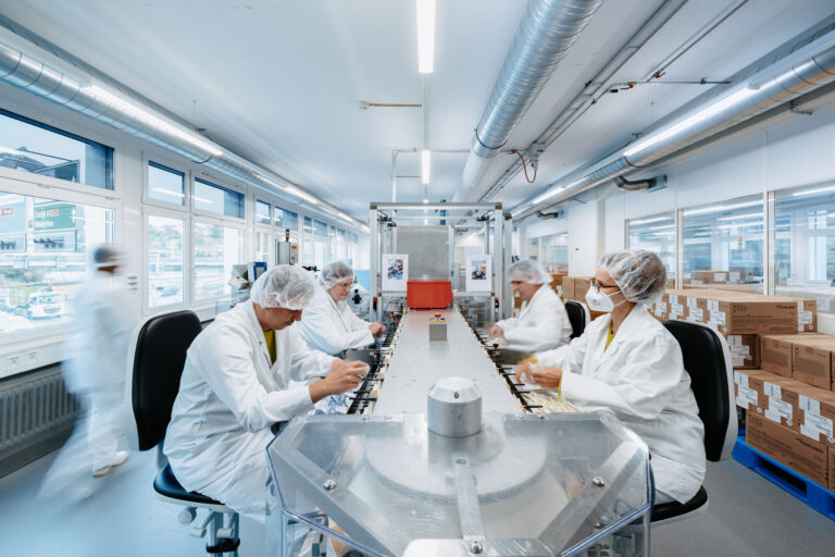 Production room with various people working on a placement line.