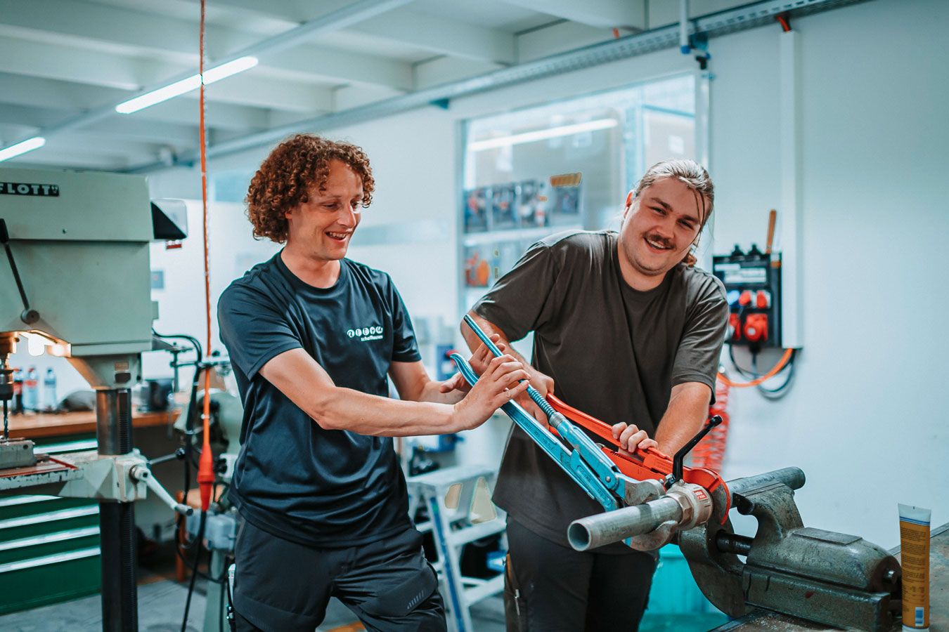 Zwei Personen mit Schraubenschlüssel bei der Arbeit.