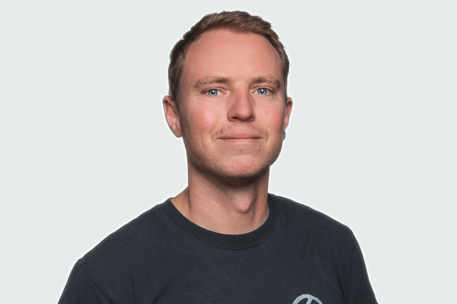 Patrick Bielitzer, Gruppenleiter Schreinerei. Er trägt ein schwarzes T-Shirt.