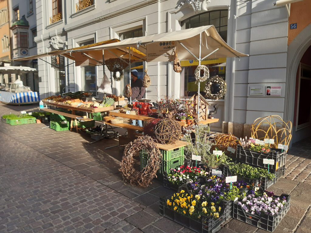 Market stall with flowers and vegetables.